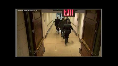 Chuck Schumer, lder demcrata en el Senado, escapaba  por un pasillo mientras dos policas iban cerrando unas puertas a su paso y sujetndolas para darle tiempo a escapar
