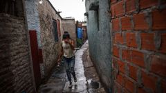 Una mujer camina por una calle del barrio marginal Puerta 8 donde se vendi� la coca�na adulterada.