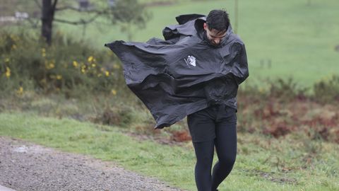 Un peregrino ayer en Santiago durante el fuerte temporal de viento
