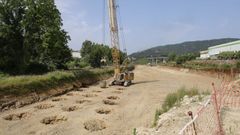 Una enorme grúa trabaja para compactar el terreno sobre el que se asentará la calzada.