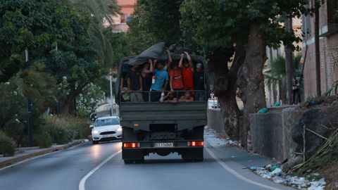 Migrantes que cruzaron a Ceuta son devueltos a Marruecos en un veh�culo del ej�rcito, el pasado domingo.
