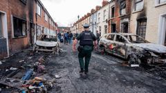 Un polic�a inspecciona los estragos causados en Belfast tras los disturbios racistas