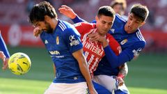 El delantero del Sporting Uros Djurdjevic lucha por el bal�n con los jugadores del Real Oviedo, Arribas y Edgar