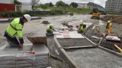 Operarios trabajando en la acera en la zona del acceso al aparcamiento desde la calle Souto.