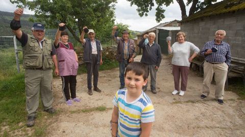 Siete de los nueve vecinos de Chandeiro con el nieto mimado de la aldea, Yago