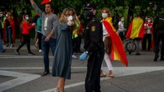 Un agente conversa con una manifestante este lunes en el barrio de Salamanca