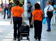 Dos cuidadoras acuden con el carro de la compra a echar una mano a una vecina del Casco Vello que no puede salir de casa.