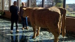 El escultor y el decano de Veterinaria, de izquierda a derecha, ante la pieza, tallada en madera.