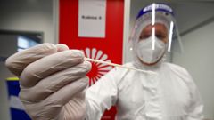 Un sanitario del aeropuerto de Dusseldorf recoge una muestra para comprobar si el virus tiene la cepa brit�nica