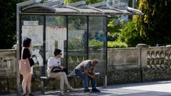 Imagen de tres lucenses esperando un bus urbano.