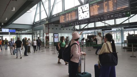 Varios pasajeros observan el panel de destinos en la estación de Santiago Daniel Castelao, la semana pasada.