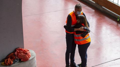 En Ginebra, dos voluntarios se reconfortan tras participar en un reparto de productos de primera necesidad entre gente sin recursos