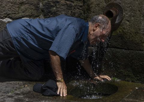 Un home refr�scase na Fonte Sequelo de Santiago en plena ola de calor. 04/07/2025