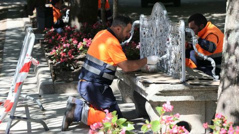 Operarios pintan los bancos hist�ricos de Sargadelos del paseo central de la Alameda