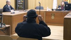 El funcionario judicial entró en la sala de vistas con la cabeza cubierta por un gorro y su cara oculta tras una mascarilla