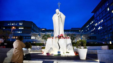 Una persona reza por la recuperaci�n del papa frente al hospital en el que permanece ingresado.