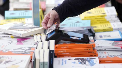 Una persona paga en un puesto de venta de libros en el centro de Barcelona durante Sant Jordi