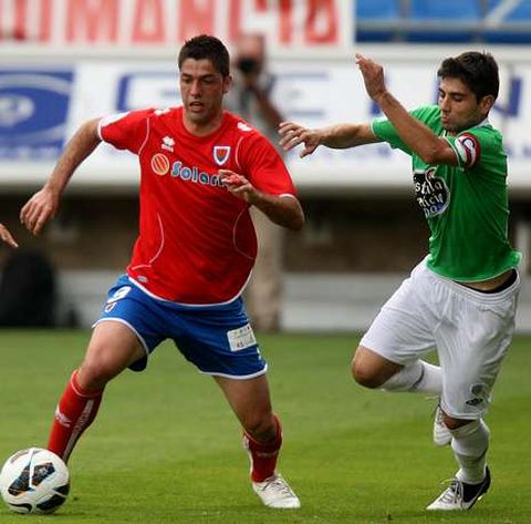 El capit�n rojiblanco Manu, presionando a un jugador del Numancia para hacerse con el cuero.