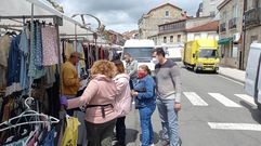 Foto de archivo de puestos de la feria en una calle de Chantada y clientes con mascarilla