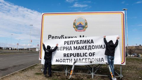 Dos operarios colocan la nueva denominaci�n en la frontera entre Grecia y Macedonia