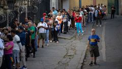 Personas hacen fila para ingresar en un supermercado este domingo, en Caracas (Venezuela)