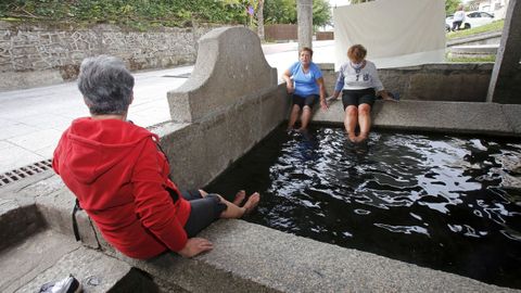 Um grupo de peregrinos refresca os ps num lavatrio em Caldas de Reis.