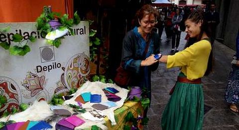 Carmen de Vega, la vendedora del producto, depilando el brazo a otra comerciante de la feria.