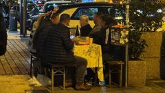 Varios turistas en las calles de Vigo instalando una mesa con mantel en plena calle