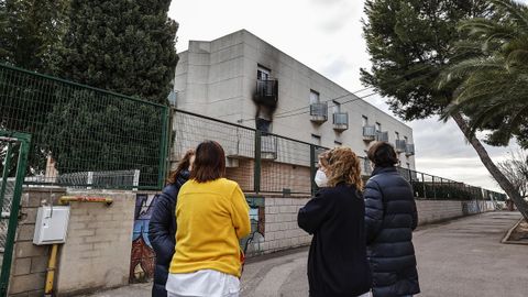 Varias personas conversan en las inmediaciones de la residencia donde se produjo el incendio