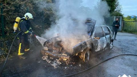 Un bombero apaga el incendio del veh�culo