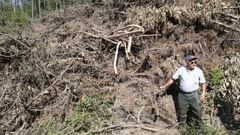 Salvador R�a, ayer, ante una monta�a de madera, ramas y maleza que lleva dos meses sec�ndose al sol en Bembrive y de la que nadie se hace responsable para retirarla a pesar de la alerta roja por el calor. A mayores, en su parroquia, a�ade R�a, el monte privado est� abandonado.