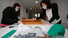 Miriam Berm�dez y Loli Polo, cortando este lunes tela para fabricar nuevas mascarillas contra el coronavirus en la escuela de costura de la segunda,en Covas (Viveiro)