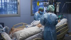 Personal sanitario atendiendo a un paciente ingresado en una Unidad de Cuidados Intensivos para enfermos de coronavirus
