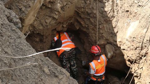 Dos rescatadores comprobando si hay supervivientes en una galer&iacute;a subterr&aacute;nea de una central hidroel&eacute;ctrica