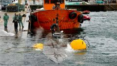 Agentes de la Guardia Civil, polica y Aduanas inspeccionan el narcosubmarino en el puerto de Aldn