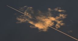 A estela dun avi�n atravesa o solpor da costa lucense. 15/07/2022