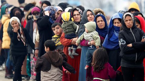 Mujeres y nios hacen cola para recibir comida en el paso turco de Pazarkule,  donde se hacinan varios miles de migrantes