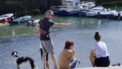 Varios turistas descansan en el Puerto de Tazones, Asturias