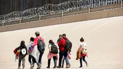 Un grupo de inmigrantes caminan por el muro fronterizo entre Ciudad Ju�rez y El Paso, despu�s de cruzar el r�o Bravo 