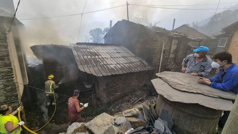 Voluntarios trabajan intentando evitar que el fuego se extienda a otra vivienda.