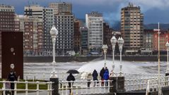 temporal olas.Varias personas caminan junto a la playa de San Lorenzo, en Gij�n
