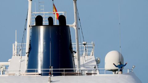 Una persona con mascarilla hace gestos a bordo del crucero MV Hondius.