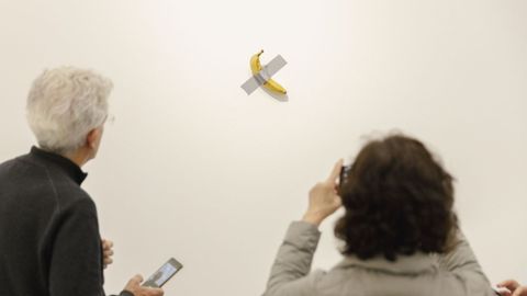 Visitantes fotograf&iacute;an la obra de Cattelan antes del robo del pl&aacute;tano, que se reemplaza cada tres d&iacute;as.