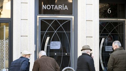 Viandantes delante de una notar�a en Lal�n