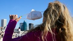 Una mujer se quita la mascarilla en Madrid