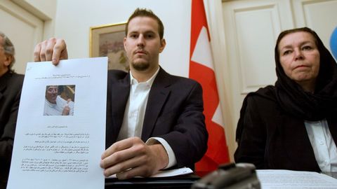 Christine Levinson observa c�mo su hijo Daniel muestra la foto de su padre a los periodistas en la embajada de Suiza en Teher�n el 22 de diciembre del 2007