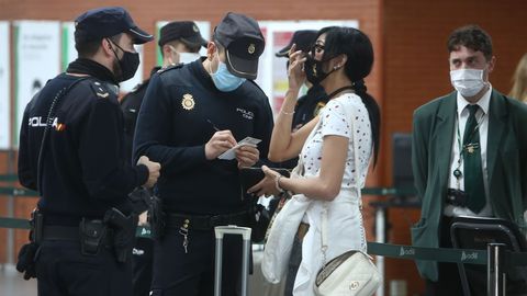 Un agente recoge los datos de una viajera que ha incumplido las normas de movilidad en Madrid