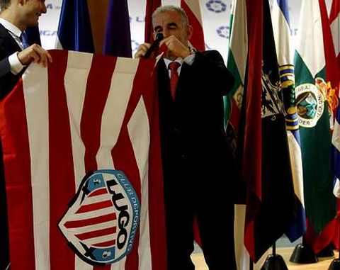 Bouso, colocando la bandera del Lugo en la sede de la LFP; a su espalda, la del Santander.