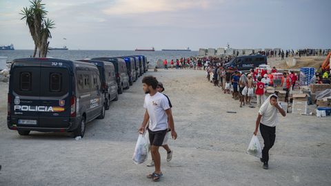 Inmigrantes recogiendo comida este mi�rcoles en la playa del Trampol�n de Ceuta