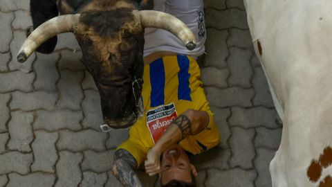 Uno mozo en el suelo al paso de un toro